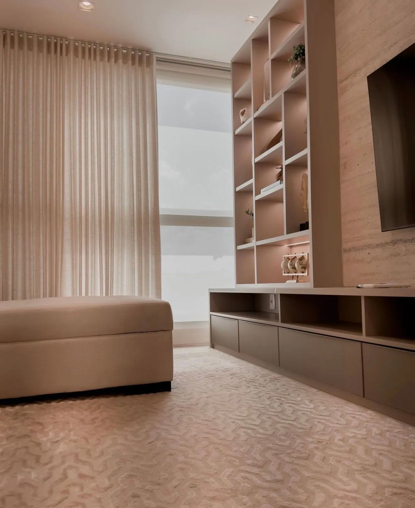 Tapete claro com textura em uma sala com sofá, cortinas e estante