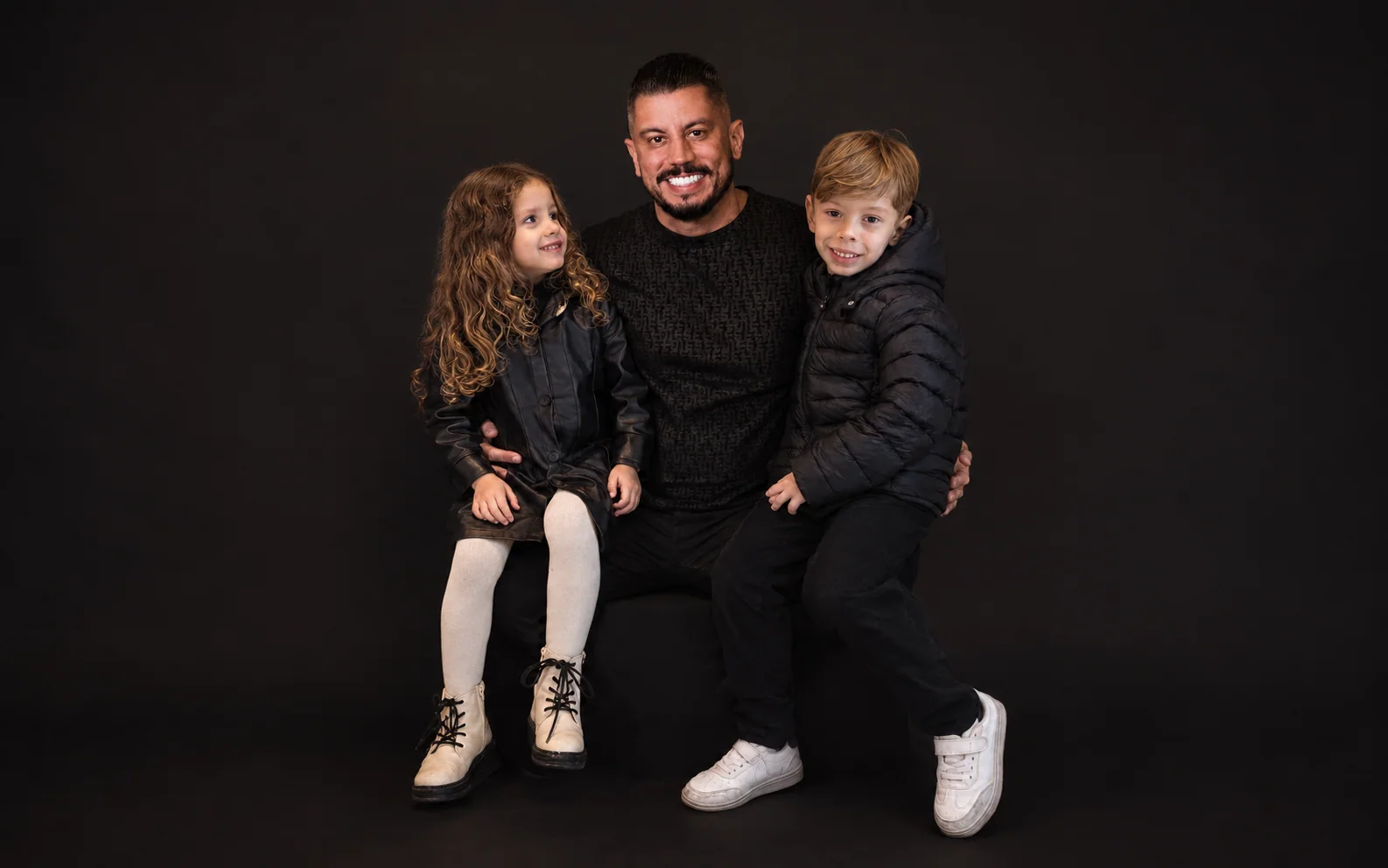 Pai com duas crianças em retrato de família — capa adaptada da imagem original