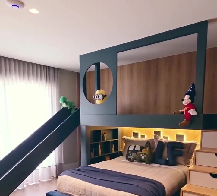 Quarto infantil com cama azul, escorregador e painéis de madeira