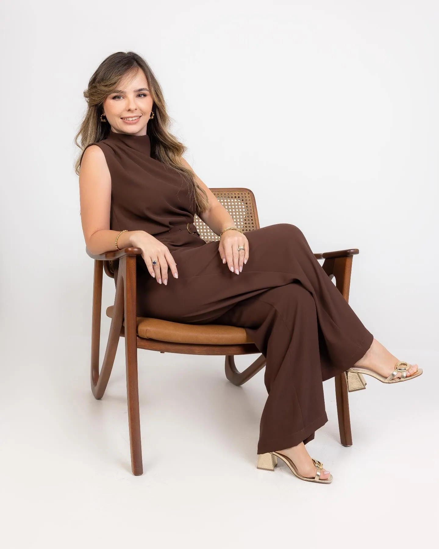Julia Rosa sentada em uma cadeira de madeira