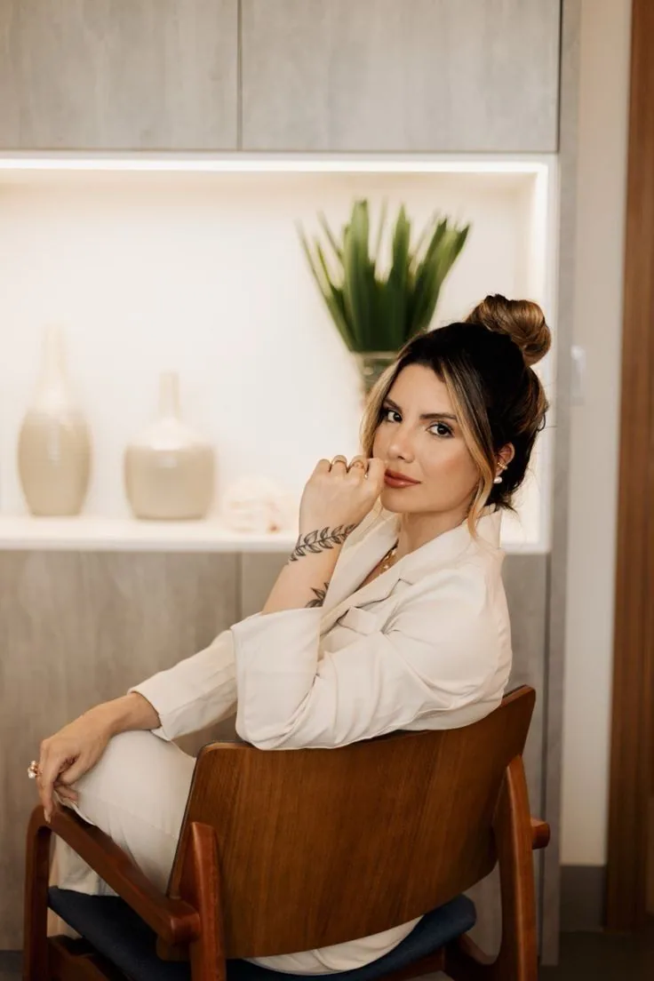 Retrato de mulher sentada em uma poltrona, na seção de depoimentos